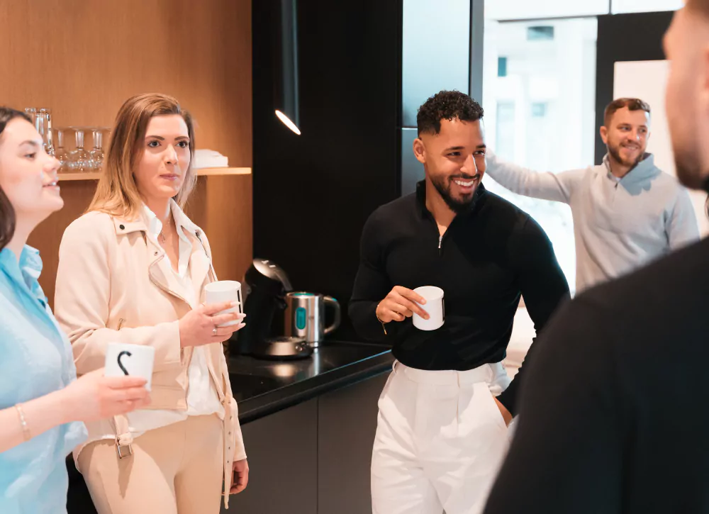 Das Team von David & Jacques Immobilien beim gemeinsamen Austausch in der Kaffeepause in der Büroküche